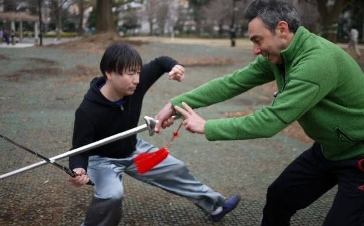 太極拳の剣で自由攻防の練習をする男性二人